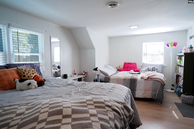 bedroom with light hardwood / wood-style floors and multiple windows