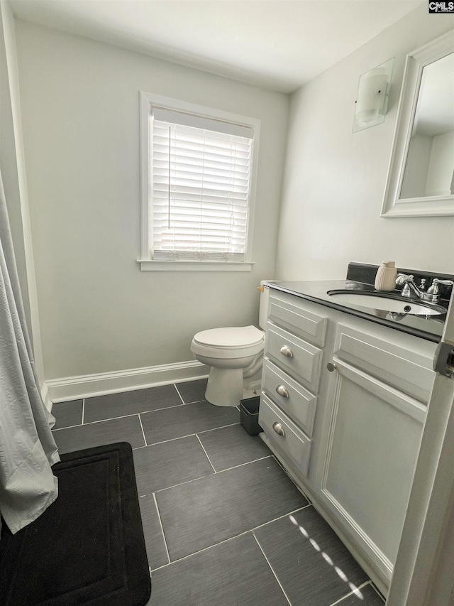 bathroom featuring vanity, toilet, and baseboards