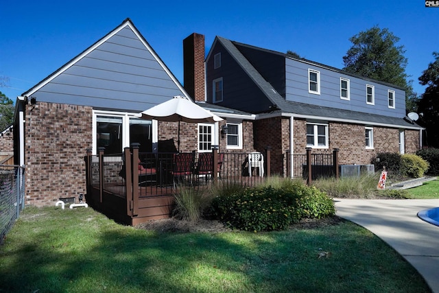 view of front of home featuring fence, brick siding, and a chimney