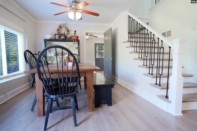 dining space featuring visible vents, crown molding, baseboards, and wood finished floors