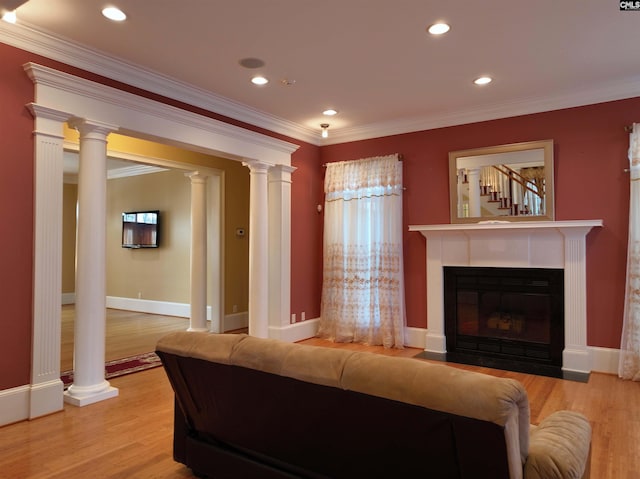 living room featuring decorative columns, ornamental molding, and light hardwood / wood-style flooring