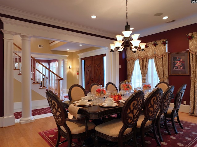 dining room featuring a chandelier, light wood-type flooring, and crown molding