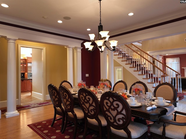 dining area with light hardwood / wood-style flooring, a notable chandelier, and crown molding