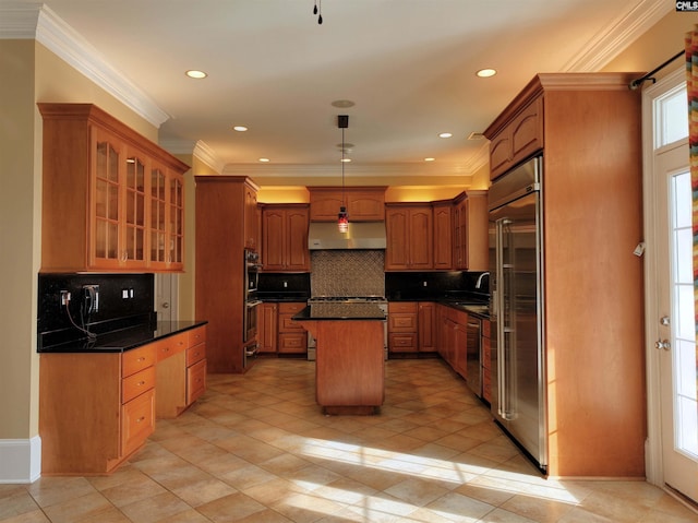 kitchen featuring stainless steel appliances, ornamental molding, backsplash, and a center island