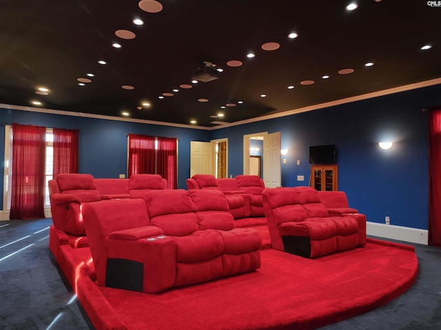 carpeted home theater room with ornamental molding