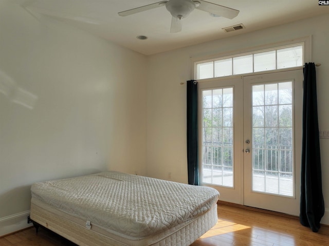 bedroom featuring light hardwood / wood-style flooring, french doors, ceiling fan, and access to exterior