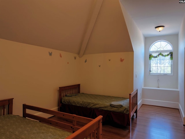 bedroom with lofted ceiling with beams and wood-type flooring