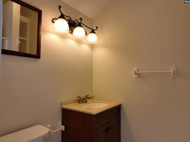 bathroom with vanity, toilet, and vaulted ceiling