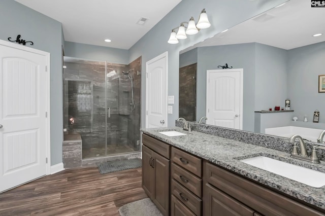 bathroom featuring hardwood / wood-style flooring, vanity, and walk in shower