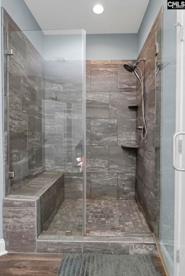 bathroom featuring wood-type flooring and a shower with shower door