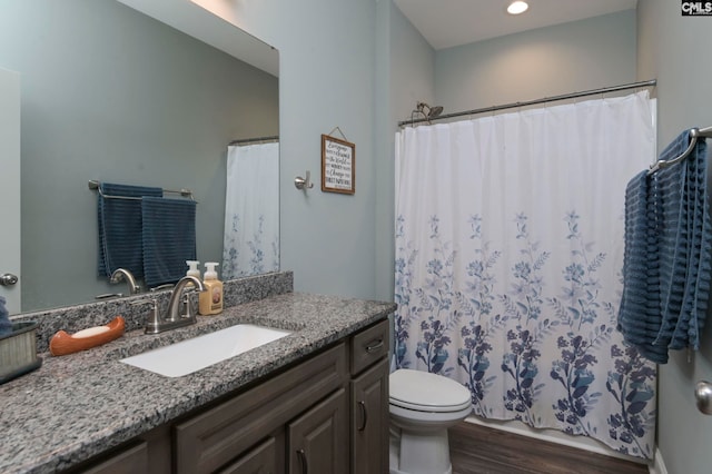 bathroom featuring toilet, vanity, and hardwood / wood-style floors