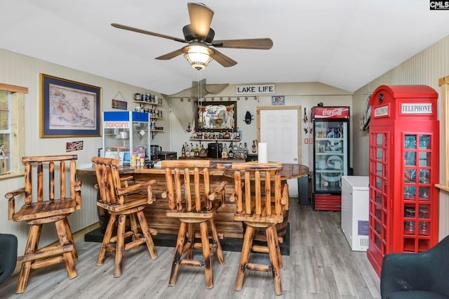 bar with hardwood / wood-style floors, lofted ceiling, ceiling fan, and refrigerator