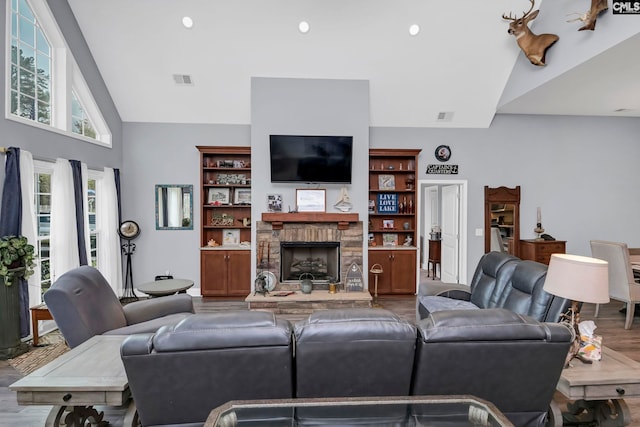 living room with a fireplace, wood-type flooring, and vaulted ceiling