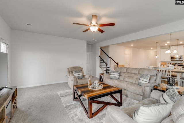 carpeted living room with ceiling fan