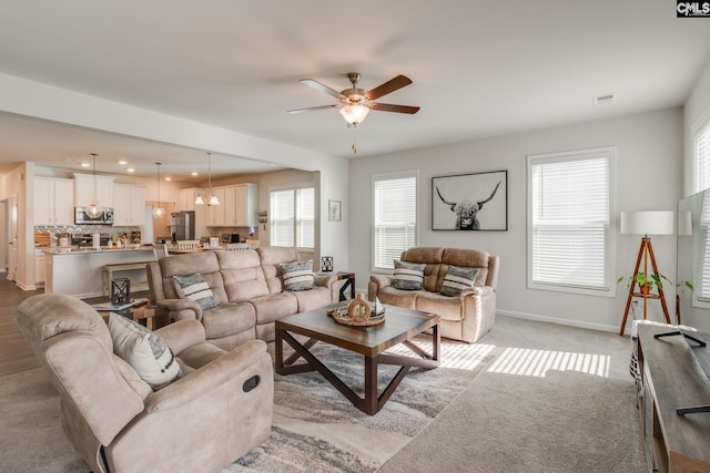 living room with light colored carpet and ceiling fan