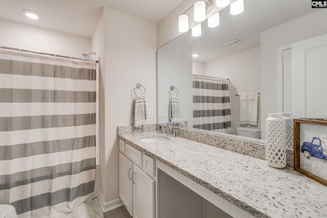 bathroom featuring toilet, vanity, and curtained shower