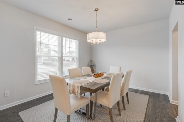 dining area featuring dark hardwood / wood-style flooring and a chandelier