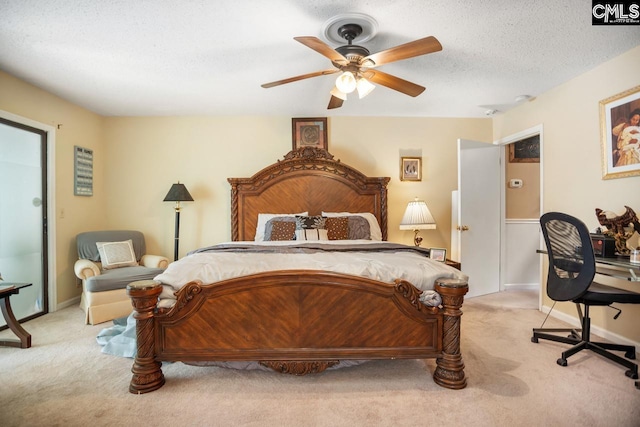 bedroom with a textured ceiling, light colored carpet, and ceiling fan