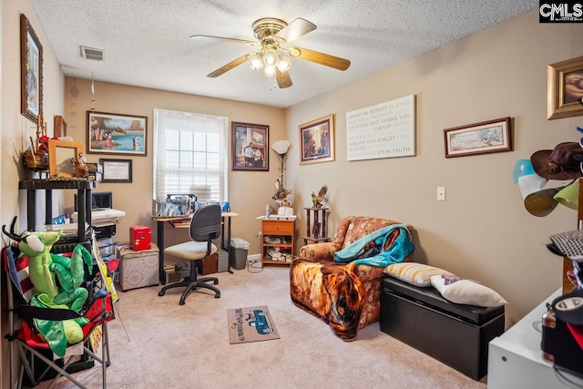 office space featuring a textured ceiling, light colored carpet, and ceiling fan