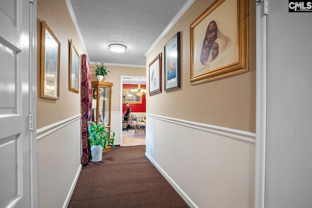 corridor featuring ornamental molding, a chandelier, a textured ceiling, and carpet