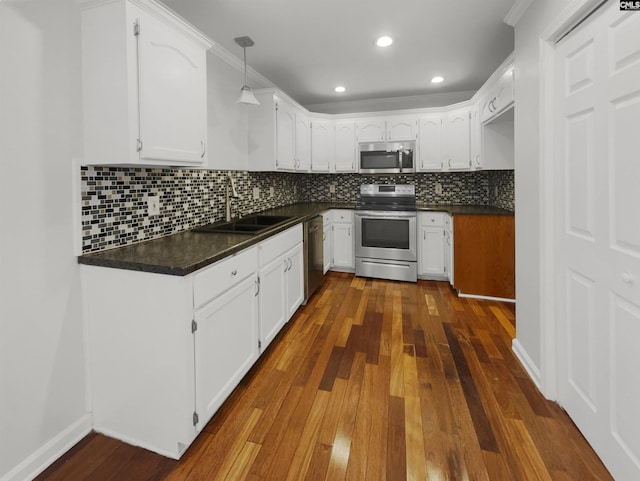 kitchen featuring appliances with stainless steel finishes, sink, dark hardwood / wood-style floors, and white cabinets