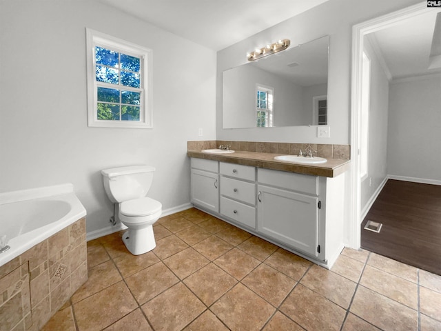 bathroom with toilet, tile patterned flooring, tiled tub, vanity, and crown molding