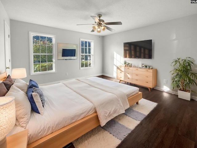 bedroom featuring ceiling fan, dark hardwood / wood-style floors, and a textured ceiling