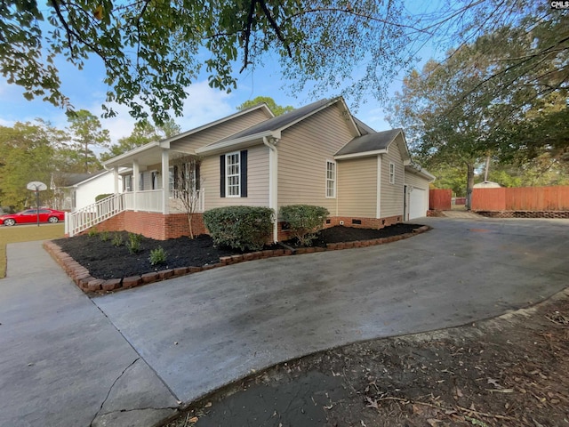 view of side of property featuring a garage and covered porch