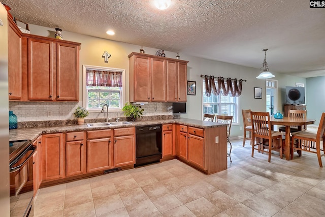 kitchen featuring decorative backsplash, black appliances, a textured ceiling, sink, and decorative light fixtures