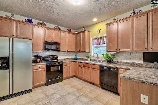 kitchen featuring black appliances, a textured ceiling, light tile patterned floors, decorative backsplash, and sink