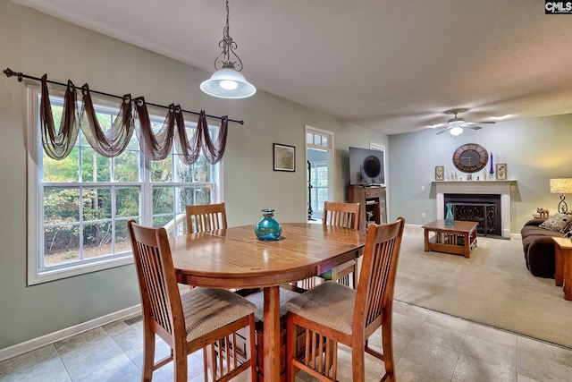 dining space with light carpet and ceiling fan