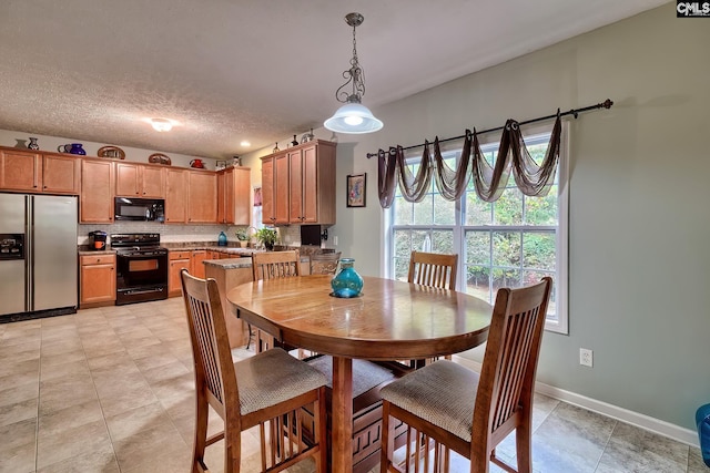 dining room with light tile patterned floors, a textured ceiling, and sink