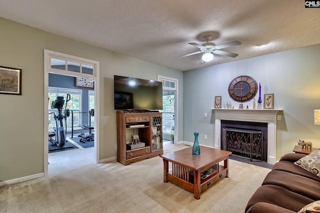 carpeted living room featuring a wealth of natural light, a textured ceiling, and ceiling fan