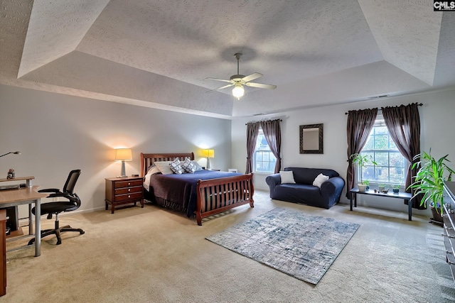 bedroom with a tray ceiling, light carpet, and ceiling fan