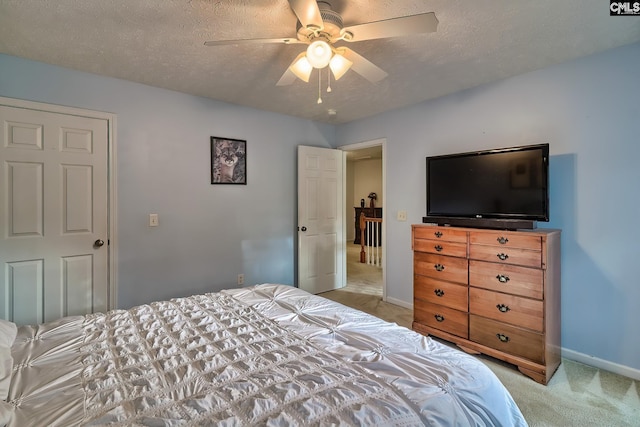 carpeted bedroom featuring a textured ceiling and ceiling fan