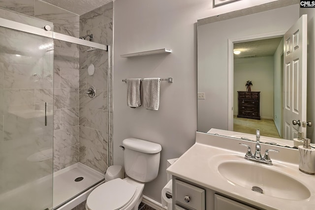 bathroom with vanity, a textured ceiling, toilet, and a shower with shower door