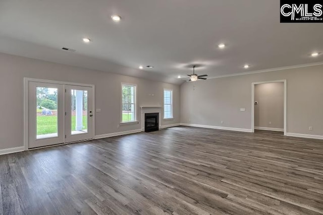 unfurnished living room featuring dark hardwood / wood-style flooring, ceiling fan, and a healthy amount of sunlight