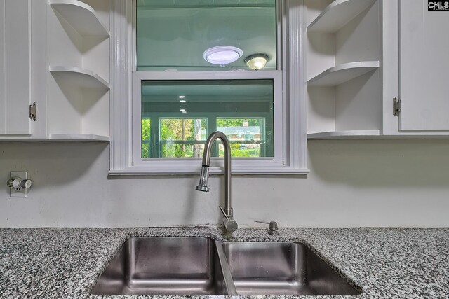 details featuring white cabinetry, sink, and stone counters