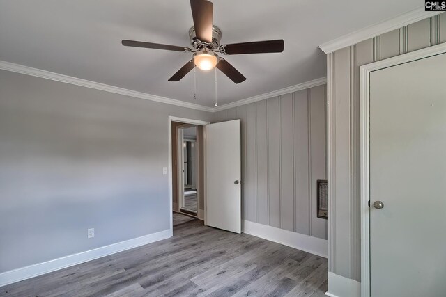 spare room with light hardwood / wood-style floors, ceiling fan, and ornamental molding