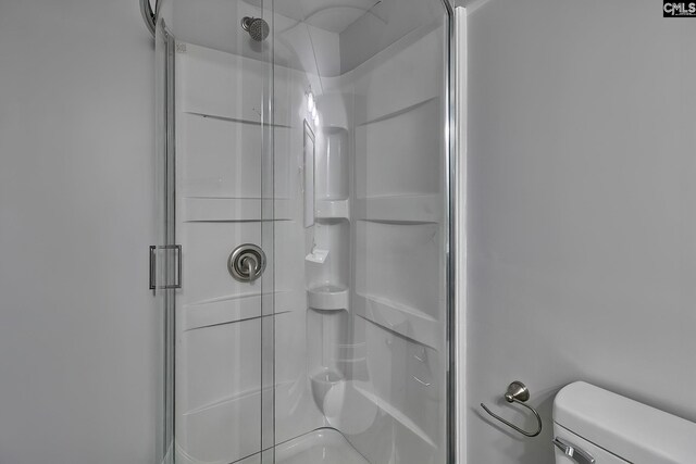 bathroom featuring walk in shower and toilet