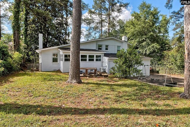 back of property featuring a lawn and a patio area