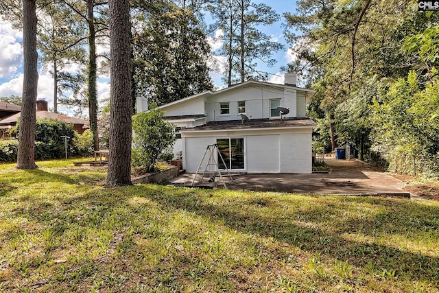 rear view of property with a patio and a lawn