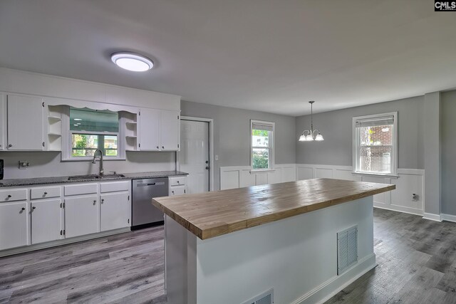 kitchen with butcher block counters, hanging light fixtures, white cabinets, and dishwasher