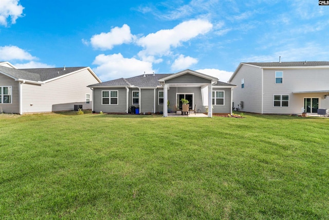 rear view of property featuring a lawn and a patio