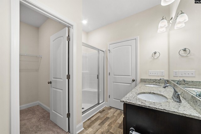 bathroom with vanity, an enclosed shower, and hardwood / wood-style floors