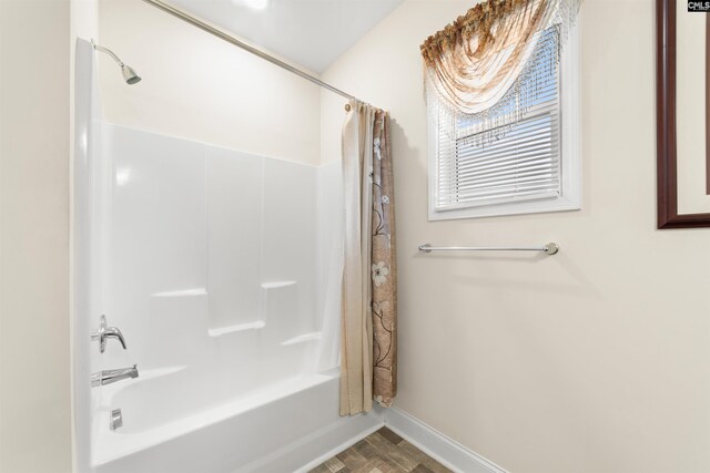 bathroom featuring hardwood / wood-style flooring and shower / tub combo with curtain