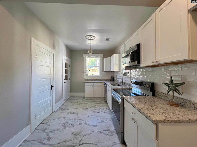 kitchen with decorative light fixtures, white cabinetry, sink, and stainless steel appliances