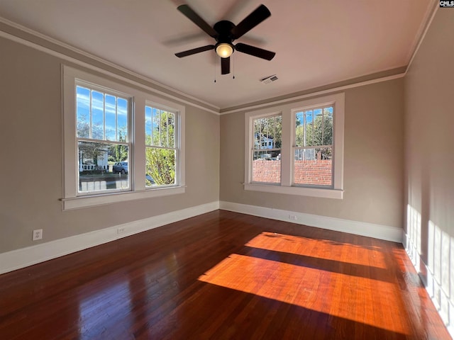 spare room with ceiling fan, a healthy amount of sunlight, dark hardwood / wood-style flooring, and crown molding