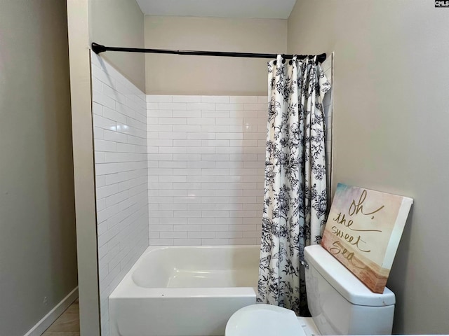 bathroom featuring shower / bath combo with shower curtain and toilet