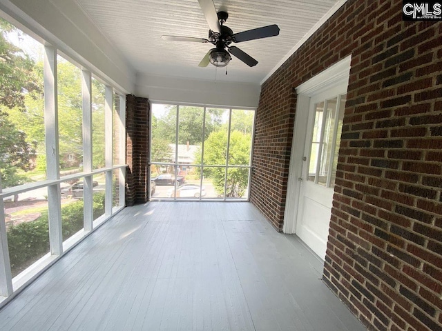 unfurnished sunroom with a wealth of natural light and ceiling fan